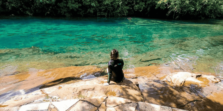 Pessoa admirando as águas cristalinas de rio em Bonito-MS