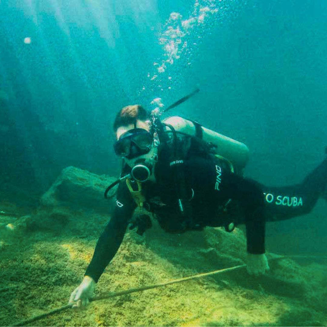 Mergulhador entediado na piscina, usando equipamento de mergulho e nadando deitado com as mãos na água, explorando o fundo do rio ou lago.